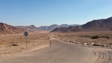 panorámica del desierto de wadi rum vista de una larga carretera remota aunque árida, barón y paisaje montañoso en el desierto árabe de jordania