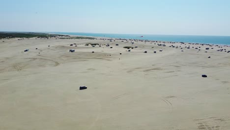 Aerial-Shot-of-Cars-Driving-on-Lakolk-Beach-on-Romo-Island-in-Denmark