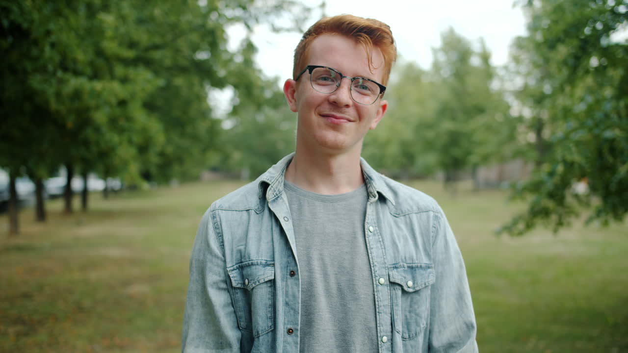 Young Man Waving Hello in a Park