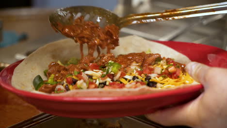 cocinero llena burrito gourmet con carne estofada, haciendo envoltura mexicana, cierre hd