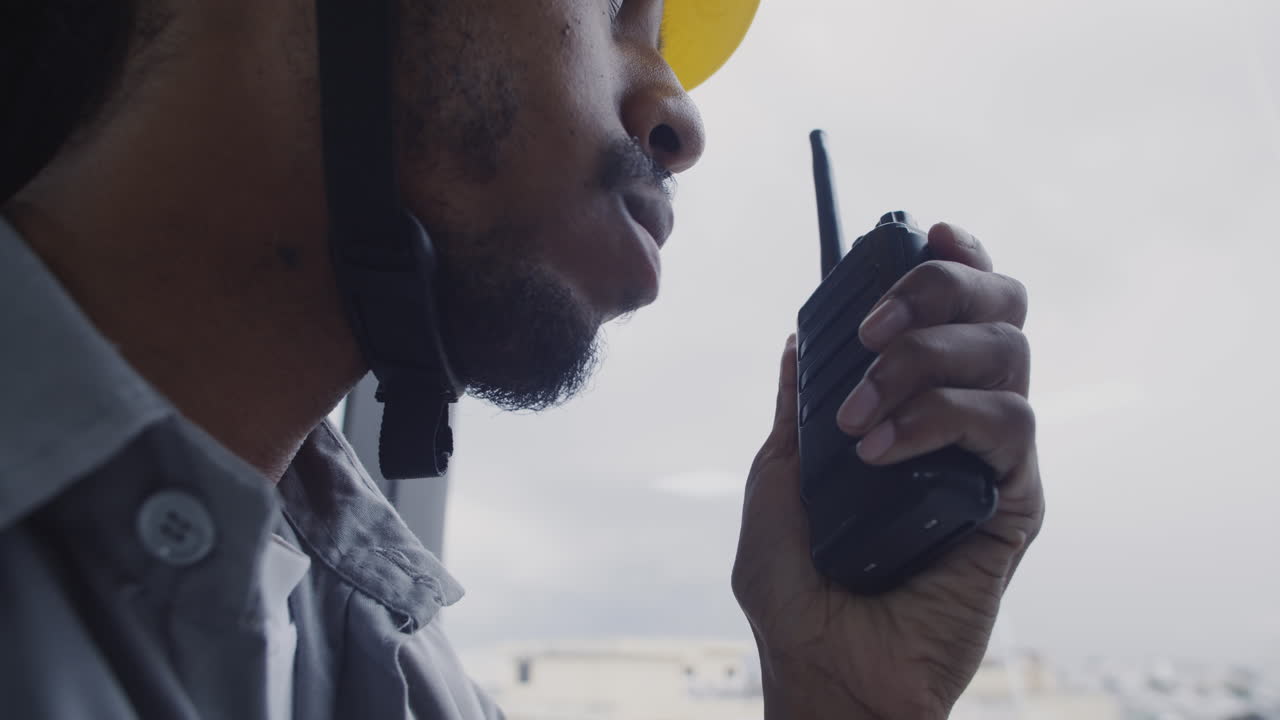 Foreman Giving Instructions to Team of Builders on Walkie-talkie