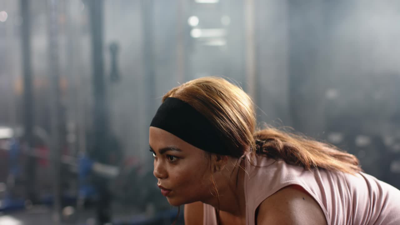 Wanita Afrika-Amerika paruh baya menggenggam barbel, melakukan deadlift untuk latihan kekuatan di gym
