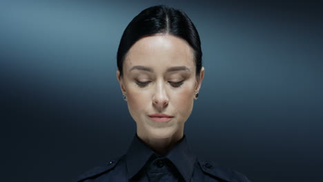 retrato de la joven trabajadora de policía de buen aspecto levantando los ojos y mirando a la cámara