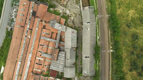 flying above deserted factory ruins next to old railway station in le sieci, florence, italy. aerial topdown shot