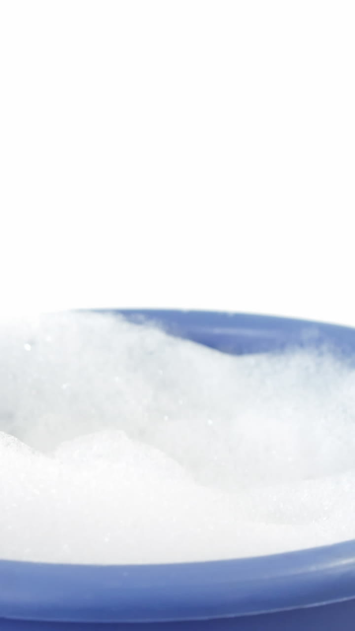 чистящая губка падает в ведро с мыльной пенкой