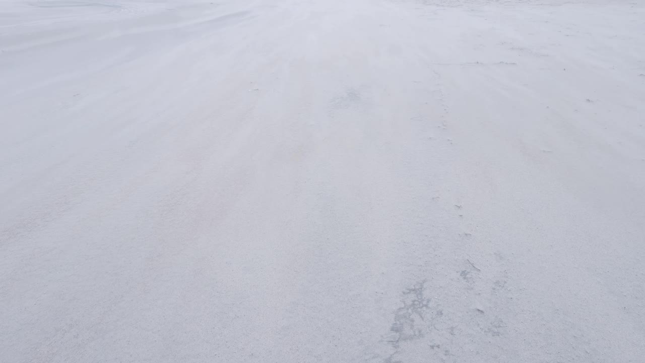 vista de la playa de arena blanca durante una tormenta de arena salvaje y ventosa con corrientes de arena volando y moviéndose a través de la superficie en west beach en berneray, hébridas exteriores del oeste de escocia, reino unido