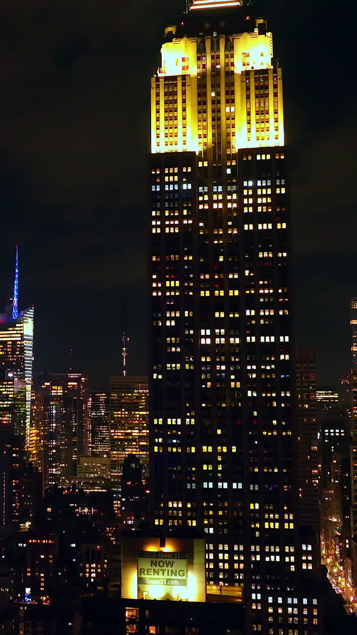 Bright shining tops of outstanding New York skyscrapers. Panorama of amazing metropolis at night. Vertical video