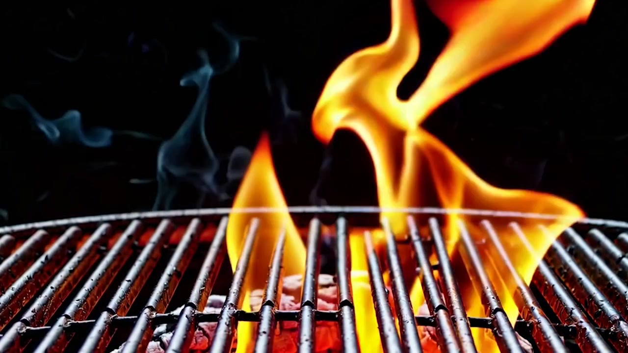 Fiamme vivaci che si alzano da un barbecue a carbone