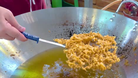 freír comida en una sartén grande en bangkok
