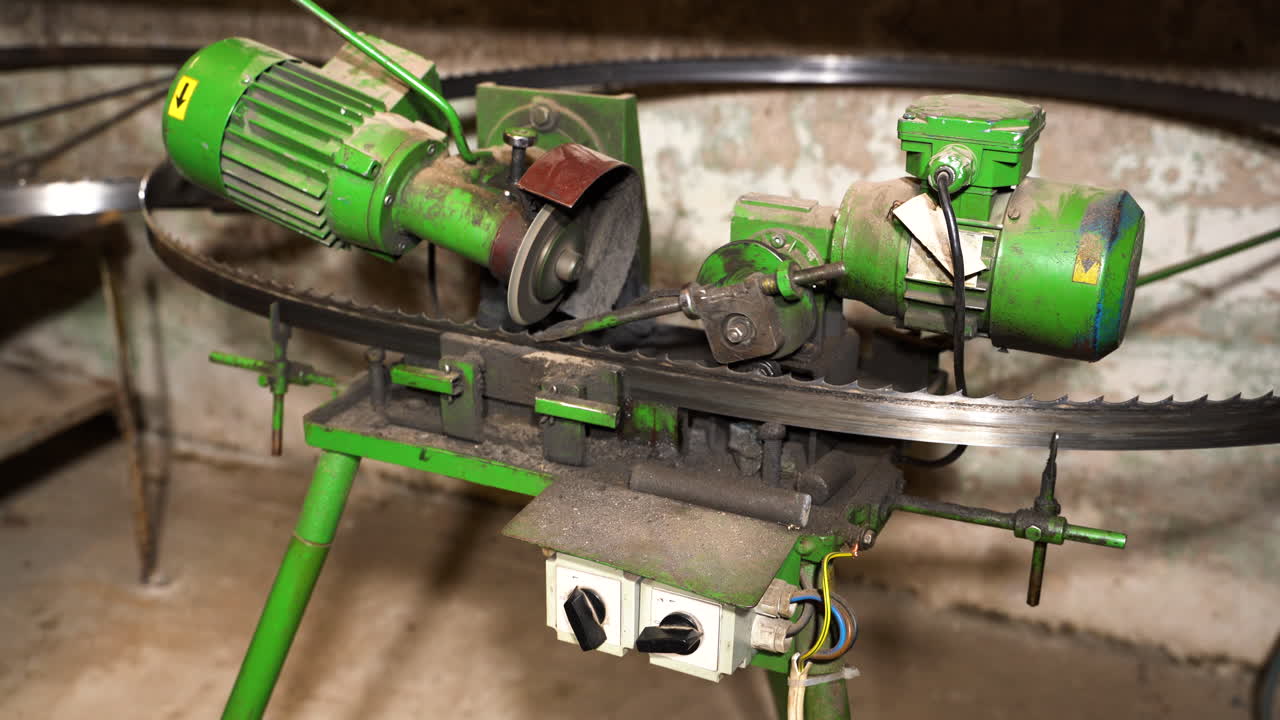 기계공이 자동 톱 밴드 샤프닝 머신을 끕니다.