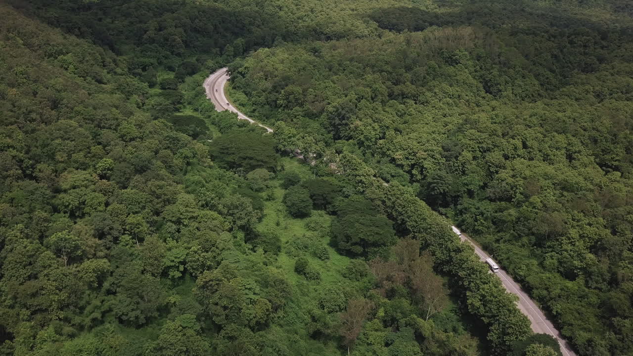 вид с воздуха на проселочную дорогу, проходящую через пышную зелень и листву тропического дождевого леса горный пейзаж
