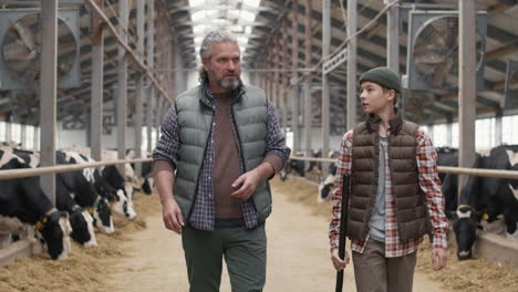 man and boy walking through dairy farm