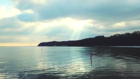 Sun-rays-going-through-clouds-above-the-seaside---drone