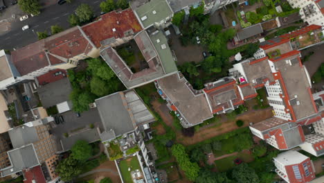 Aerial-birds-eye-overhead-top-down-panning-view-urban-neighbourhood.-Flying-over-buildings,-parks,-town-courts-and-streets.-Berlin,-Germany.