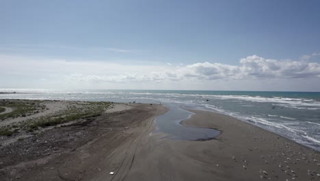 video with drone a few meters from the sea on the beach of spille, the coast of albania, frontal plane with ascent, seagulls can be seen flying as the drone passes