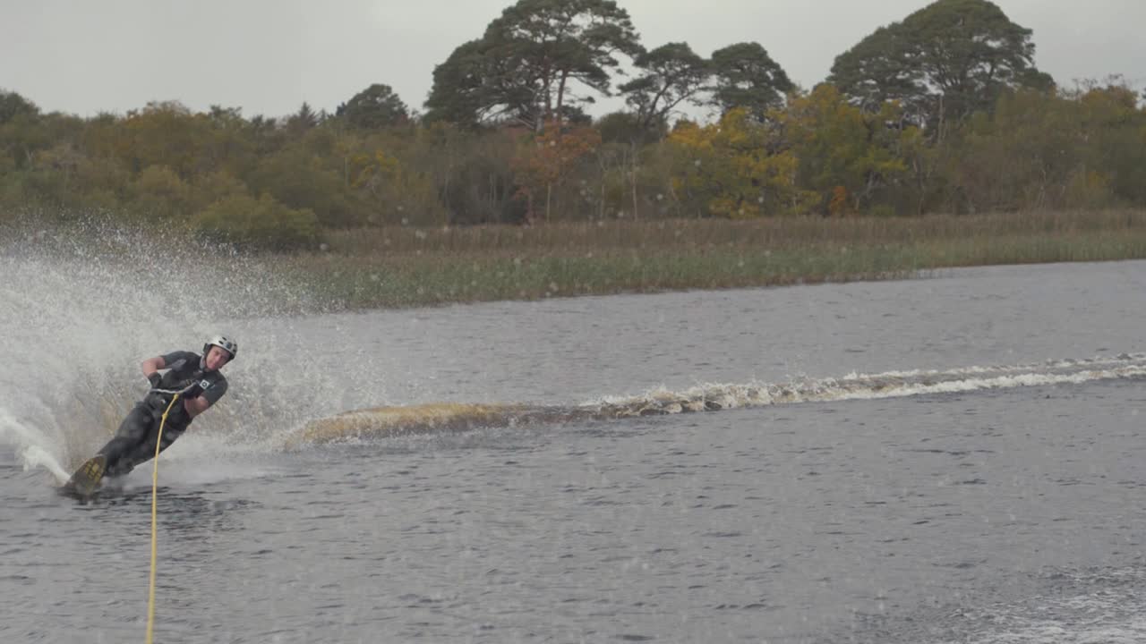 젊은 슬라럼 수상 스키 선수가 부표 주위를 꽉 잘라냅니다.