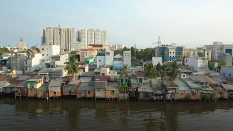 classic drone shot with contrast of old and new buildings along the canal waterfront in district eight of ho chi minh city, vietnam