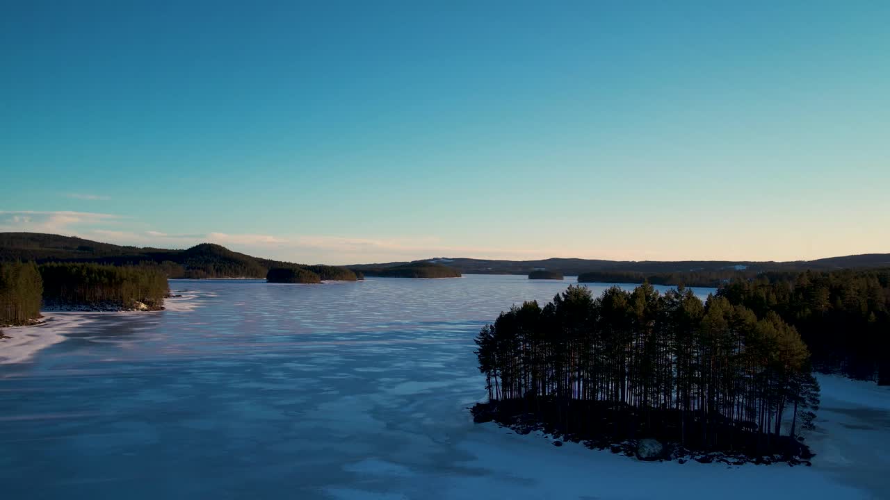 夕焼けに染まる凍った湖の空撮