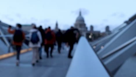 people walking over a city bridge