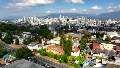 Volando-Por-Encima-De-La-Calle-Principal-Hacia-La-Avenida-12-En-Vancouver-Con-Vista-Del-Horizonte-En-La-Distancia