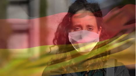German-flag-waving-against-woman-wearing-face-mask