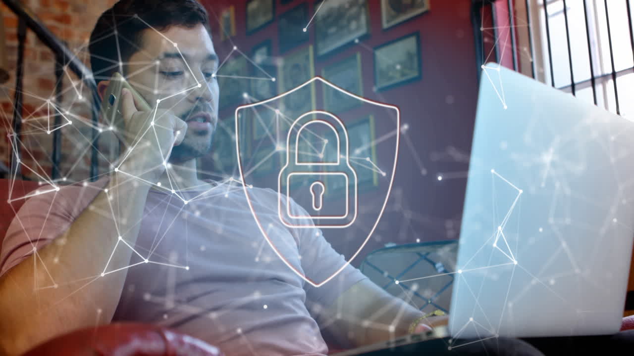 animación de un candado en el escudo, puntos conectados, hombre biracial hablando en teléfono celular mientras usa una computadora portátil