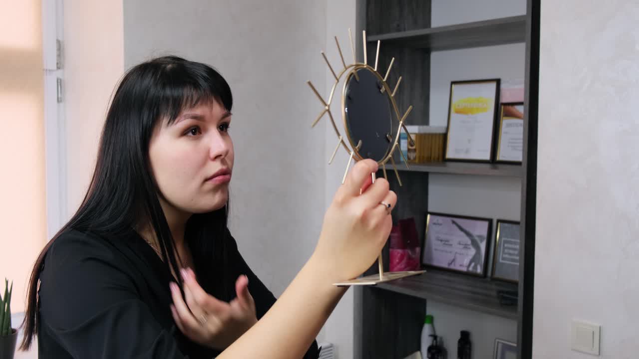 거울을 보고 웃고 있는 화장에 감탄하는 여자