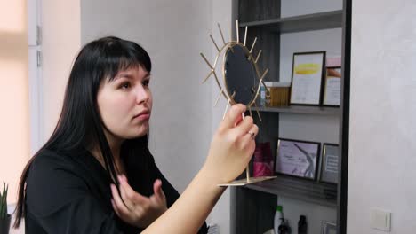 woman admiring makeup looking in the mirror and smiling