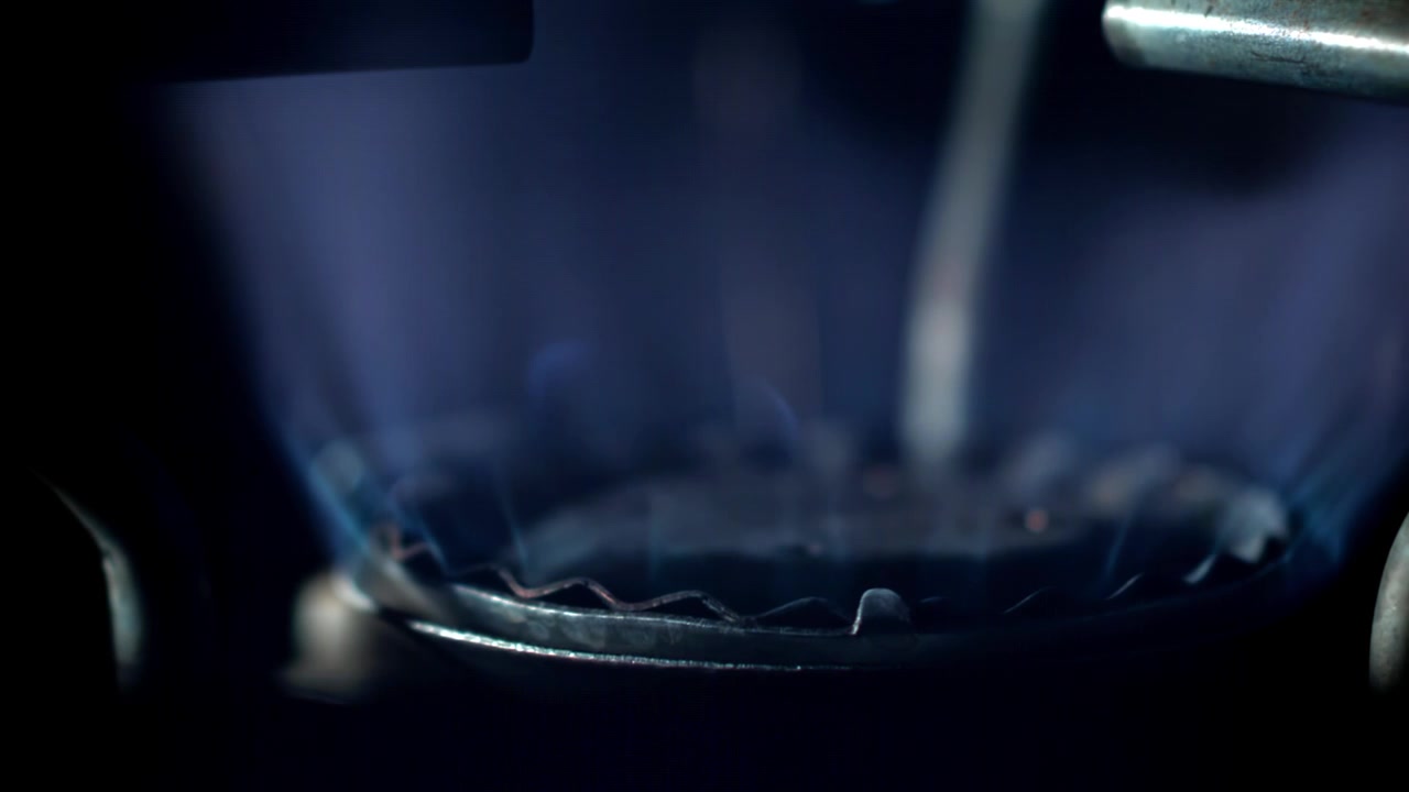 Bruciatore del fornello a gas che si accende con fiamma blu nell'oscurità