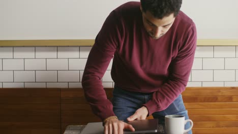 hombre trabajando en una computadora portátil en un café