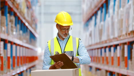 Warehouse-worker-writing-on-clipboard