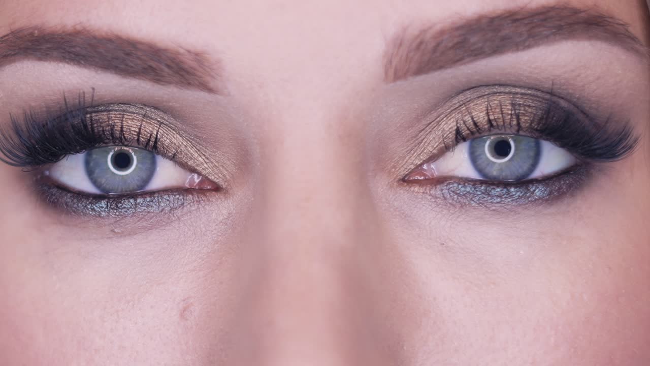chica sensual abre los ojos con ojos de humo efecto maquillaje
