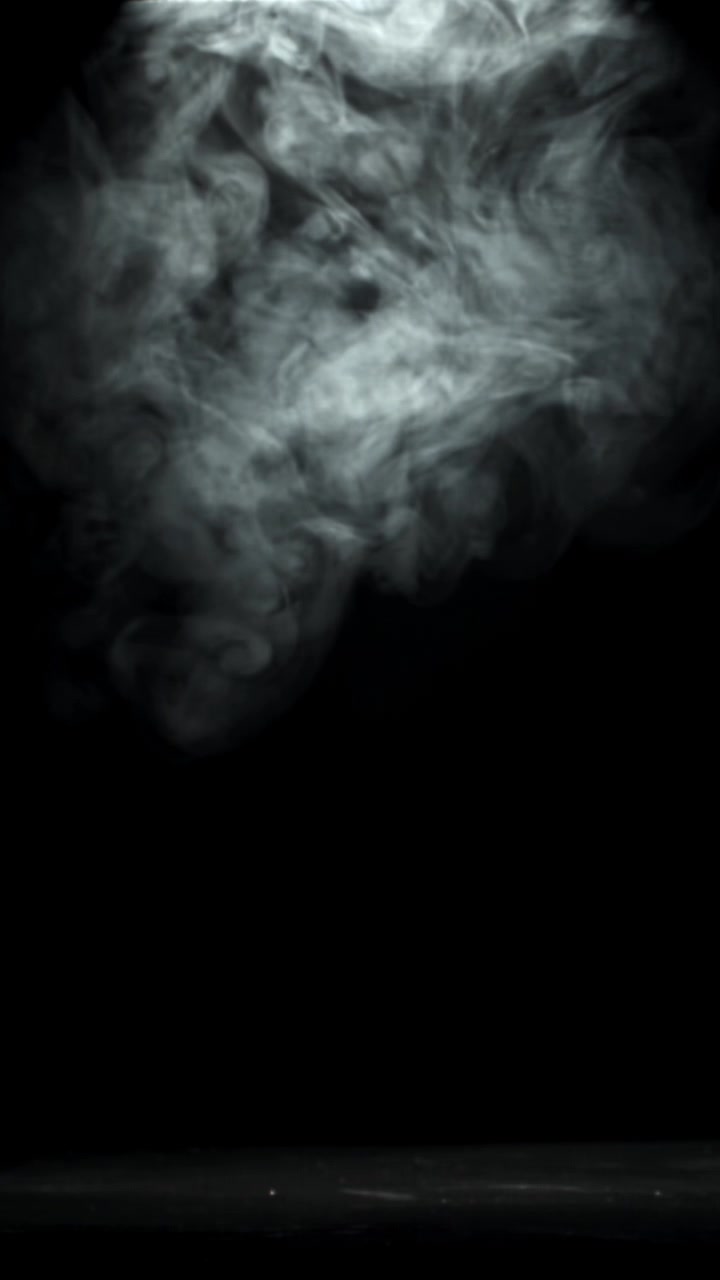Fumo bianco che si innalza e turbina su sfondo nero