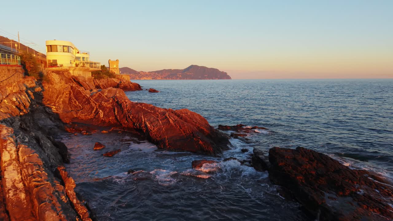 Golden hour drone view of rugged coastline, with cliffs and the sea in Genoa, Italy