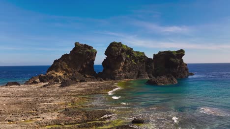 Disparo-De-Un-Dron-Que-Muestra-Rocas-En-La-Isla-De-Las-Orquídeas-Con-Olas-Del-Océano-Pacífico,-Taiwán