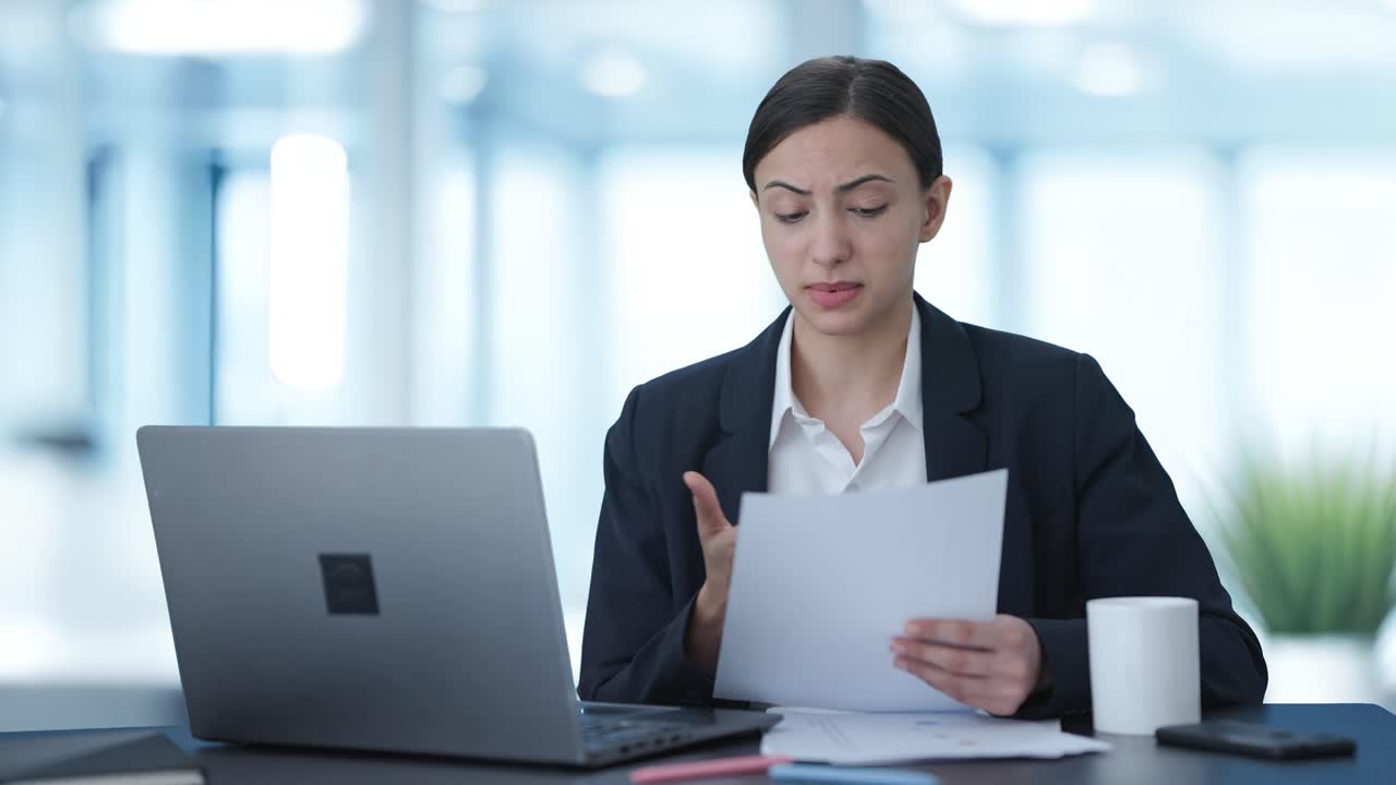 una mujer india seria haciendo una videollamada