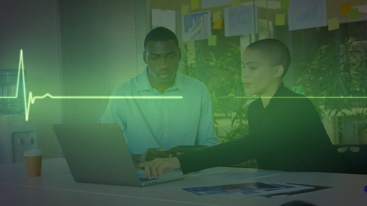 Animation of cardiograph over diverse business people using laptop