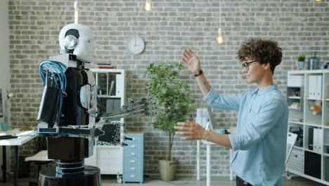 smiling woman controlling robot testing response, machine copying movements
