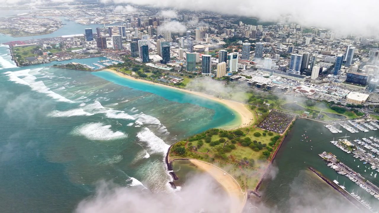 Vista aerea con drone del parco sulla spiaggia, del porto turistico e dei grattacieli della città lungo la costa, Honolulu, Stati Uniti