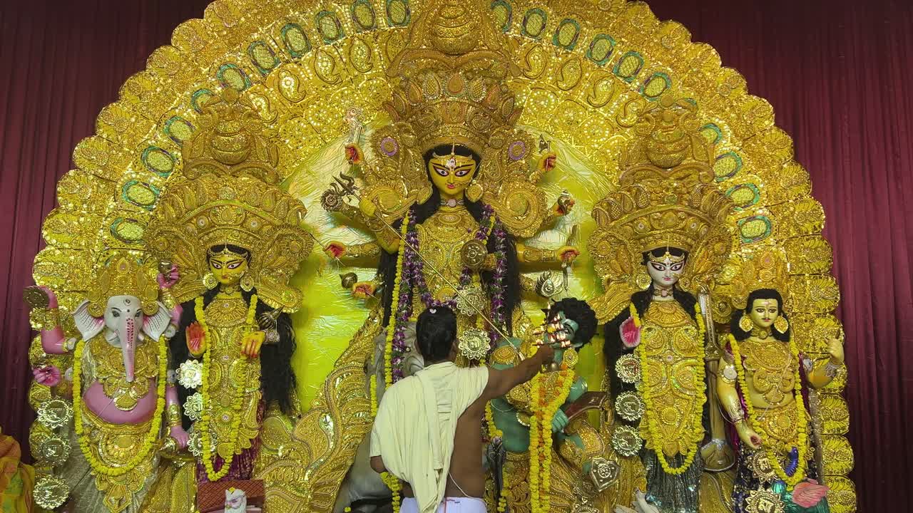 An Indian man offering prayers to Goddess Durga during puja in Kolkata.