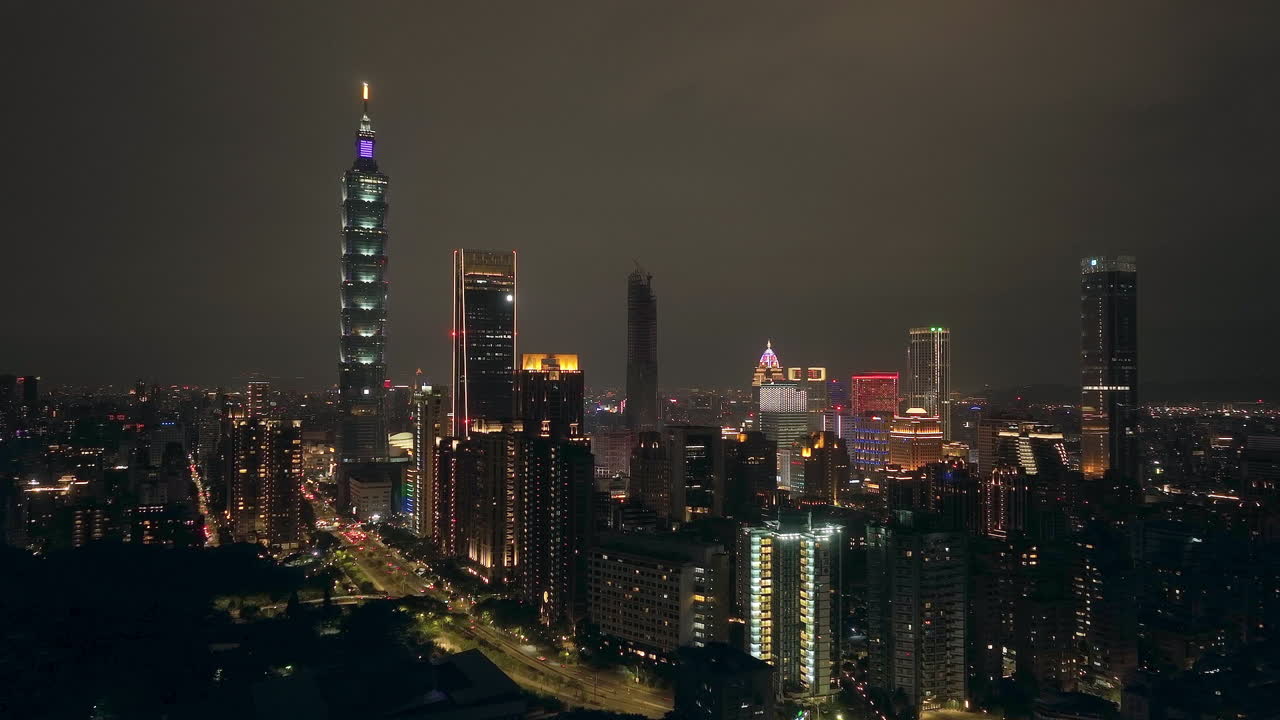 Aerial forward flight showing illuminated skyline of Taipei City at night