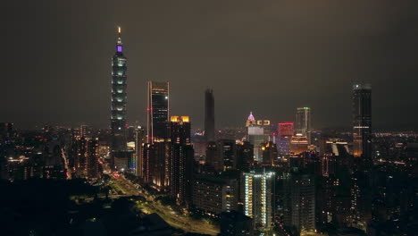 aerial forward flight showing illuminated skyline of taipei city at night