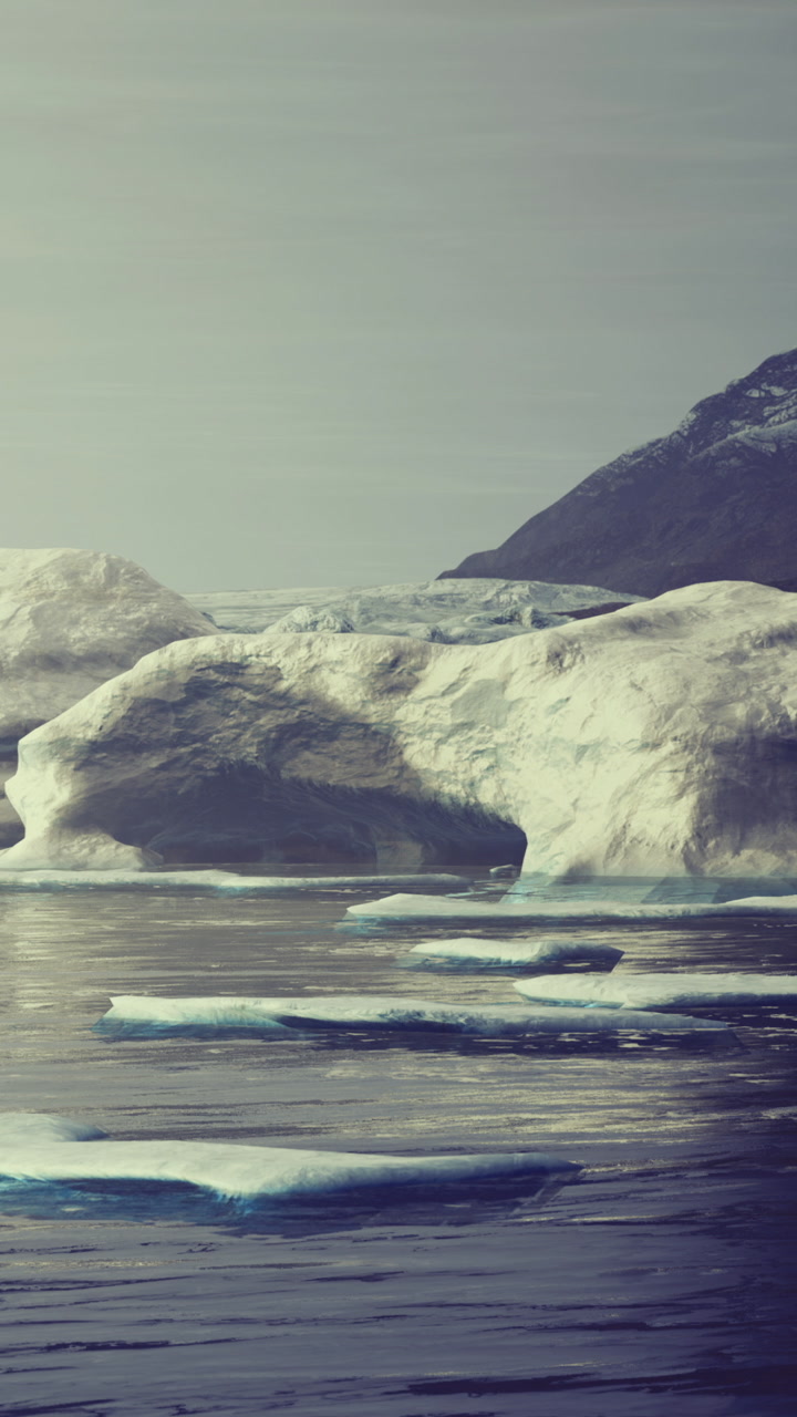 Large icebergs float in calm water near a glacier in arctic region