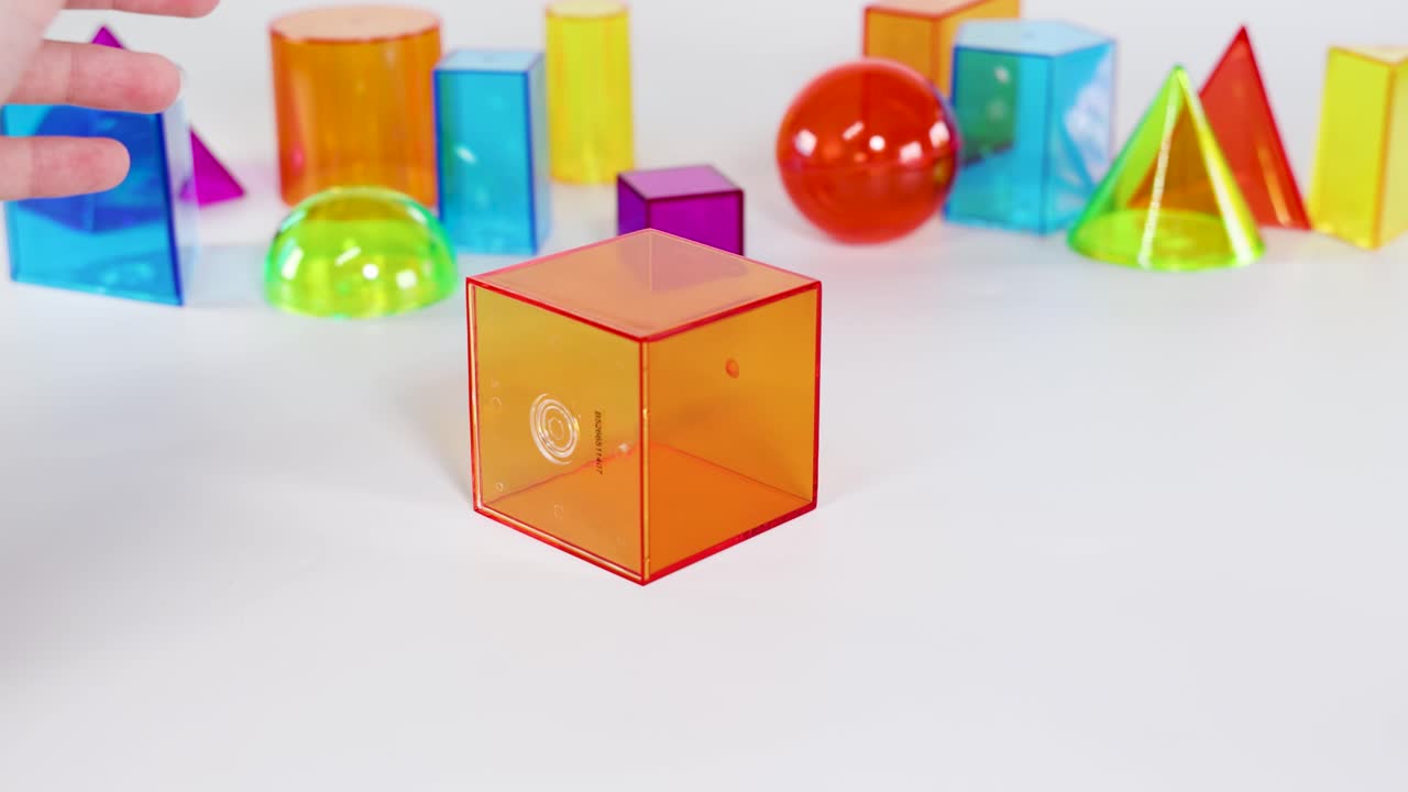 A sequence showing hands interacting with colorful 3D geometric shapes on a white surface, highlighting educational and playful elements