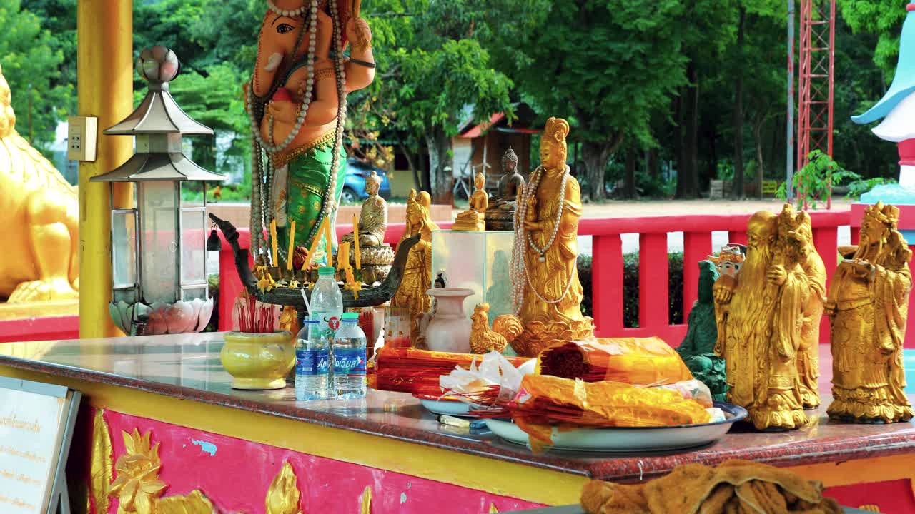 เครื่องประดับพุทธศาสนาไทยพร้อมรูปปั้นอยู่เบื้องหลังที่วัดกุดคล้า เขาใหญ่