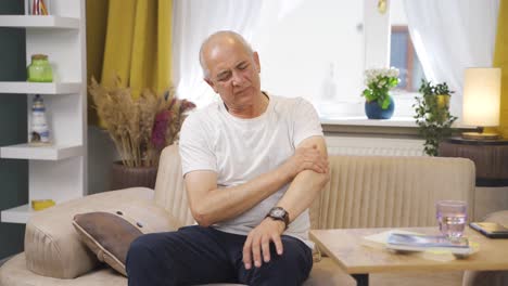 un anciano con dolor en el codo.