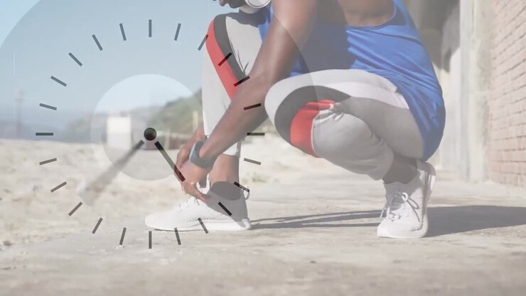 Animation of clock over african american man tying shoe before running