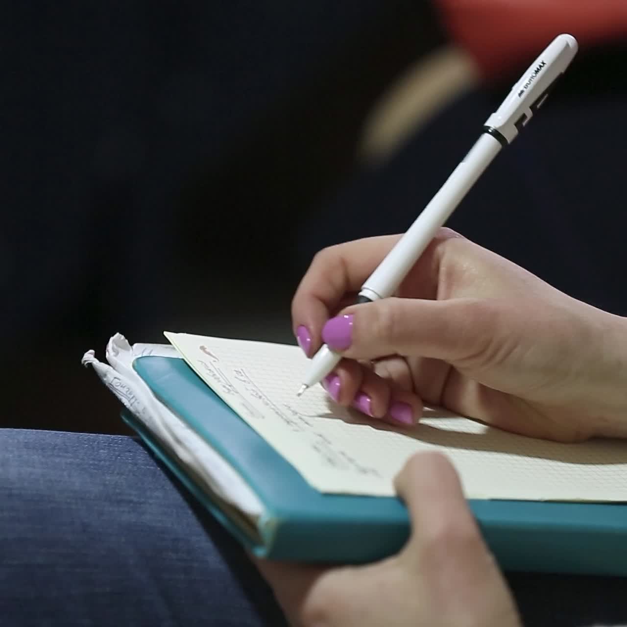 manos tomando notas en la conferencia