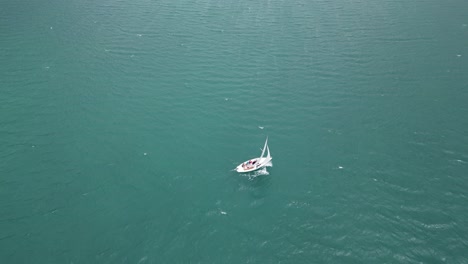 Peaceful-relaxing-scene-of-yacht-sailing-in-tranquil-lake-waters-in-Switzerland