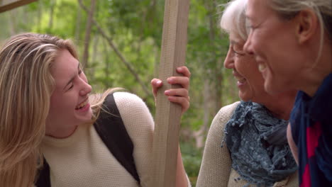 three generations of woman laughing in a forest, slow motion